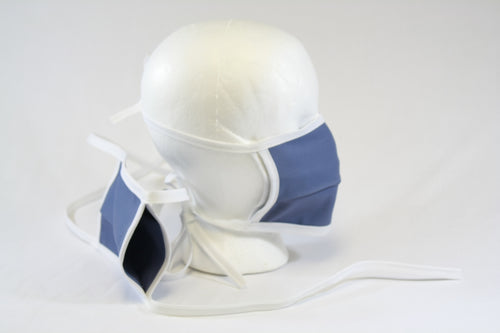 Double layer mask on a mannequin head and another mask off to the side showing the open pocket, which can be used to put in a filter.